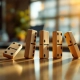 Vijf houten domino's vallen in sequentie op kantoorbureau, toont domino-effect en oorzaak-gevolg reactie